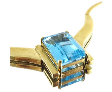 An 18 carat gold and blue topaz necklace, the central emerald cut stone approx. 1.7cm x 1.3cm, supported within a twin horned