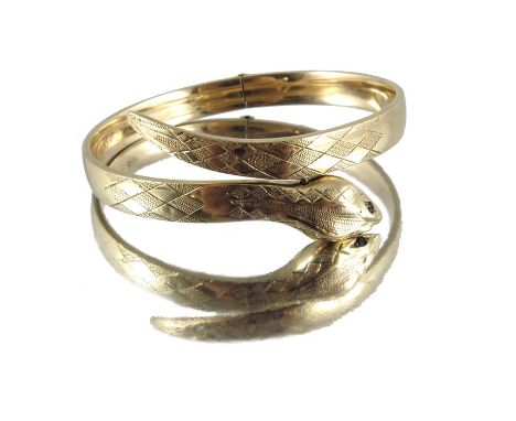 A 9 carat gold bangle in the form of a snake, set with garnet eyes, hinged to the back, London 1963, 19.9g