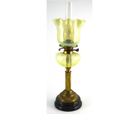 A 19th century straw opal glass oil lamp and shade, the optic ribbed ovoid reservoir supported on a brass column stand and bl