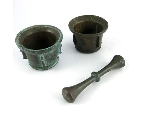 Two 17th century Spanish bronze mortars and a pestle, of cylindrical pan top form, each with fin decoration, one cast as pila