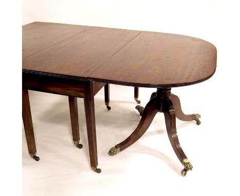 A large George III mahogany D end dining table, circa 1810, the two tilt top pedestal ends on four legged sweeping supports a