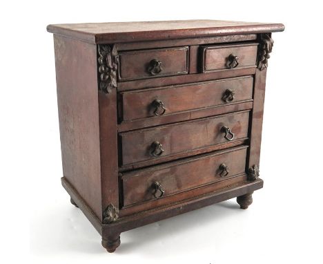 An early Victorian mahogany miniature chest of two short over three long drawers, circa 1840, acanthus and grape moulded brac