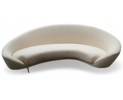 A contemporary Bourjois Boheme sofa - of curved form, upholstered in a pale yellow textured fabric raised on short brass cabr