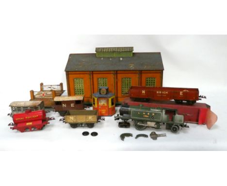 A Hornby 0 gauge clockwork tank engine - in green livery with rolling stock in a distressed box, with level crossing and tinp