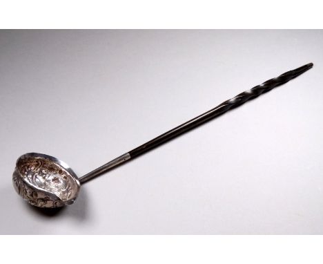 An 18th/19th century silver toddy ladle - the bowl set with a shilling and fitted with a contorted baleen handle, length 36cm