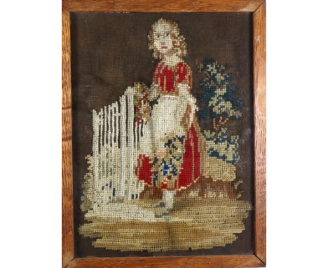An 18th century needlework of a young girl standing at a gate - with tree beyond, framed and glazed in an oak frame, overall 