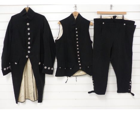 A Georgian gentleman's tailcoat, waistcoat and breeches all in black cloth, the coat silk lined with ornate cut steel buttons