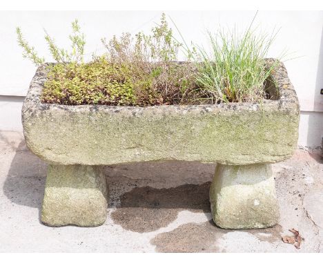 A weathered stone planter on two stone plinths length 92cm