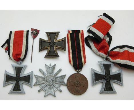 German WWII medals comprising three Iron Crosses, a War Merit Medal with ribbon, War Merit Cross with swords together with an