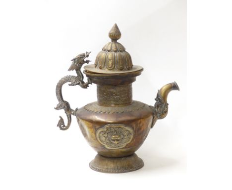 A 19thC Tibetan copper and brass ceremonial teapot and cover with zoomorphic dragon handle and two cartouches featuring deiti