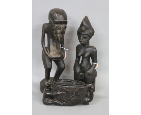 TRIBAL ART, two African carved wooden figures, one standing, bird style face, hands clutching a swollen belly, the other of a