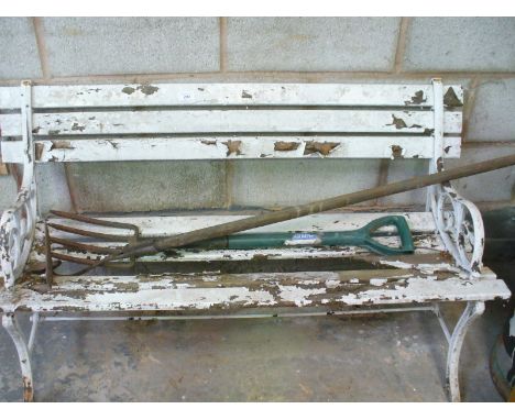 A Painted iron and slatted hardwood bench, a garden fork and hoe.