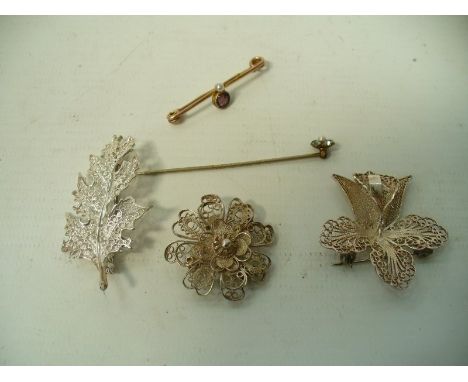 An amethyst and seed pearl brooch
To yellow metal, together with, three white metal filigree brooches and a paste stick pin (