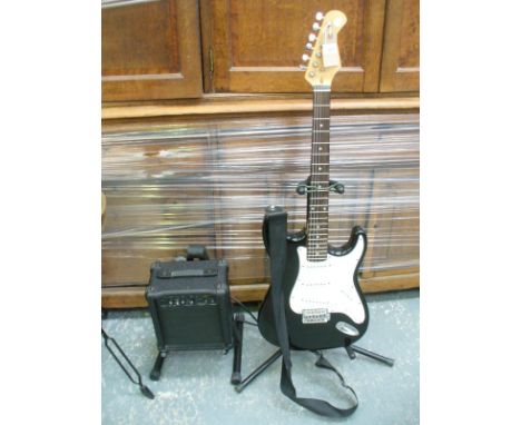 A Burswood stratocaster style electric guitar , amplifier and 2 stands.