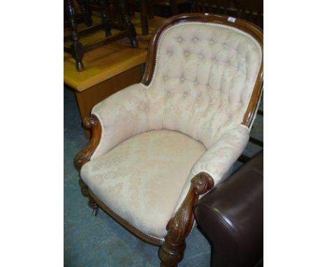 A Victorian mahogany balloon back drawing room chair, with padded button back and two padded arms, each with leaf carved term