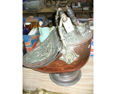 A Victorian copper coal helmet  with an ebonised turned handle above a concave hinged cover embossed with a bat wing design a