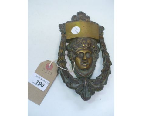 A Cast brass mask and leaf door knocker.