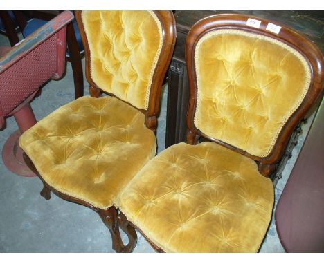 A Pair of Victorian walnut and golden velour button back side chairs with French curvilinear front legs.
