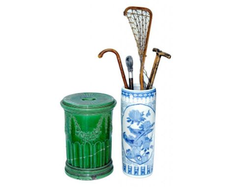 A SHOOTING STICK, SEVERAL OTHER STICKS, A VICTORIAN GREEN MAJOLICA GARDEN SEAT (DAMAGED) AND A LATER BLUE AND WHITE STICK STA