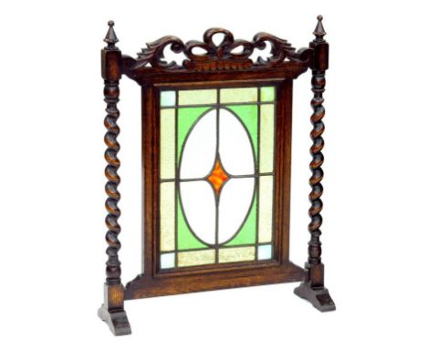 A CARVED AND DARK STAINED OAK AND LEADED GLASS FIRESCREEN, EARLY 20TH CENTURY