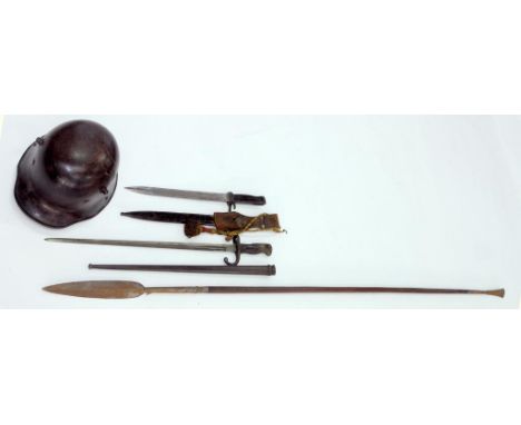 A WORLD WAR TWO GERMAN SOLDIER'S HELMET, TWO BAYONETS AND A DOUBLE ENDED SPEAR WITH HARDWOOD SHAFT, LATE 19TH C