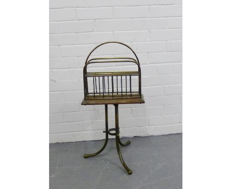An Edwardian brass and oak revolving magazine rack on tripod supports, 75cm high x 36cm