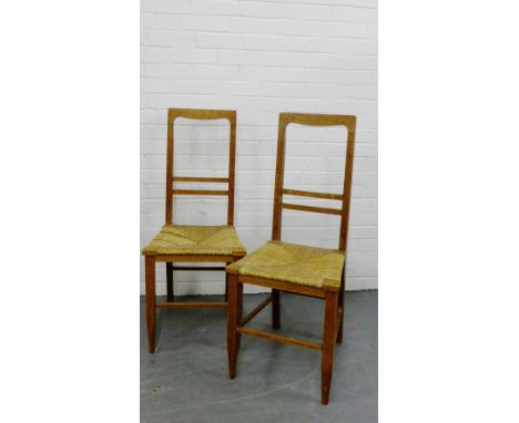 A pair of light oak Arts & Crafts side chairs with rush seats and tapering supports (2) 