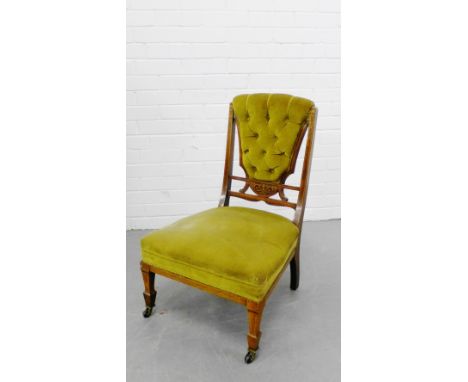 A rosewood and inlaid nursing chair with a button back, an upholstered seat on inlaid tapering supports terminating in brass 