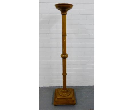 A light oak Art Deco torchere on turned supports and stepped plinth square base on bun feet, 138cm high 