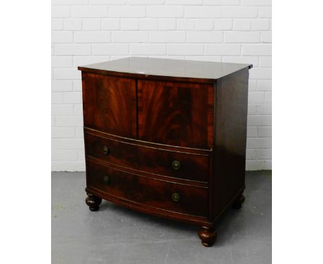 A mahogany bow front commode, the lift up top over two dummy drawers raised on bun feet, 76 x 74cm