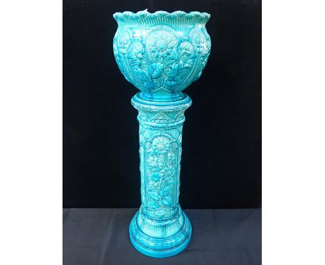 A BURMANTOFTS FAIENCE JARDINIERE AND STAND moulded with sunflowers with turquoise glaze, No.1947B and 1948B, 96cm high (small