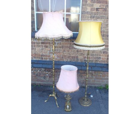 A BRASS TRIPOD STANDARD LAMP of 19th century style, another metal standard lamp and a gilt metal table lamp with inset porcel