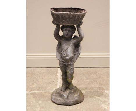 A figural lead planter, modelled as a putti holding a basket aloft, upon a naturalistic rocky base, 76cm high 