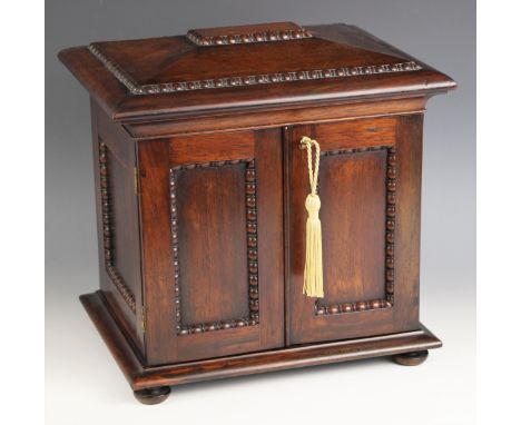 A William IV rosewood table top work box, the sarcophagus shaped hinged cover applied with moulded beaded detail, opening to 