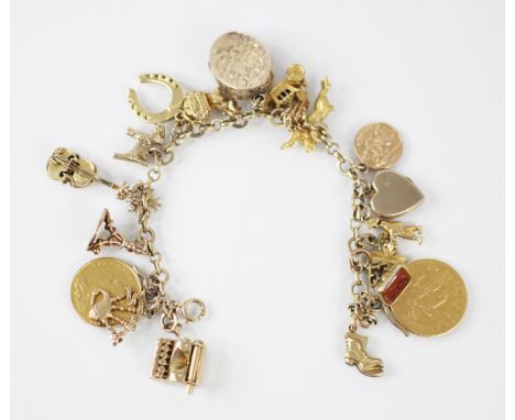 A yellow metal charm bracelet, the trace link chain suspending twenty one charms including carnelian set seal, a half soverei