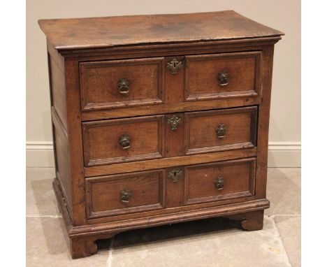 A Jacobean oak chest of drawers, the plank top above an arrangement of three elm lined long drawers, each moulded as two draw
