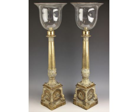 An impressive pair of 19th century Empire style brass candle holders, mid 20th century, the inverted bell shaped glass shades