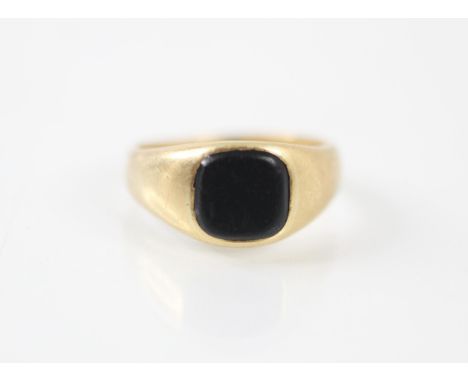 A yellow metal and onyx set signet ring, the square onyx matrix set within wide shoulders and plain polished shank, stamped 1