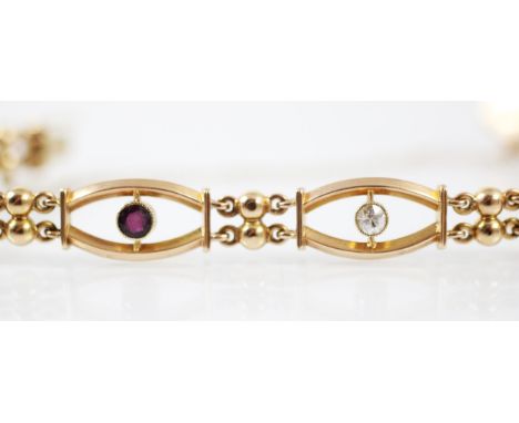 An Edwardian diamond and ruby set bracelet, the seven openwork panels with an alternating ruby or old cut diamond set to cent