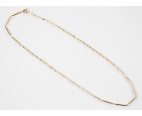 A yellow metal necklace, the necklace designed as twenty-six plain polished barrels, with bolt ring fastening stamped ‘375’ o