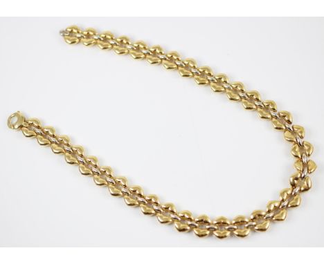 A two tone yellow metal necklace, the necklace designed as fancy oval shaped links with one side showing white metal spacers 