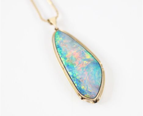 A precious opal necklace, the stylised tear drop slice of opal within a yellow metal Art Nouveau style mount, with plain poli