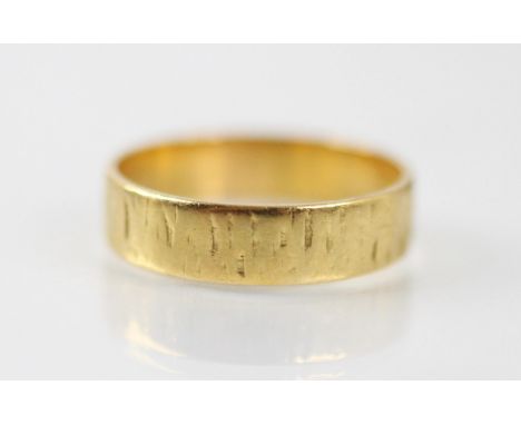 A 22ct yellow gold wedding band, with textured decoration, stamped 'SH' Birmingham possibly 1973, ring size N, 3.9gms 