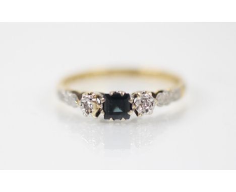 A mid-20th century sapphire and diamond three stone ring, the square cut sapphire white metal claw set with illusion set diam