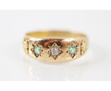 A Victorian gypsy ring, the central old cut diamond with an emerald to each side, set within an 18ct yellow gold shank, stamp