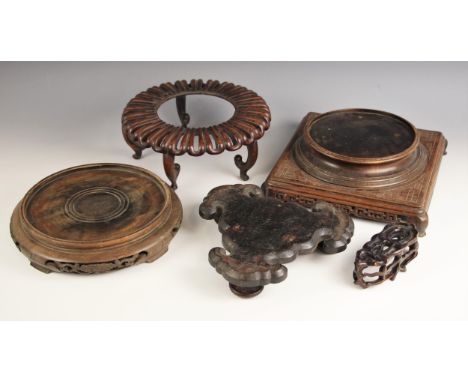 A collection of four Chinese carved wood vase stands, comprising; an unusual circular stand with radial lobed gallery raised 