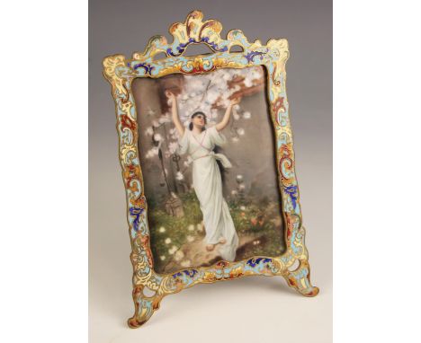 A French porcelain plaque, late 19th century, depicting a classical maiden beneath a prunus tree, within a champlevé enamel s