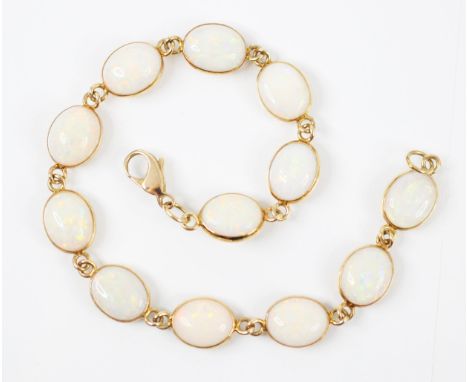 An 18ct yellow gold white opal bracelet, the twelve oval cabochon opals within a yellow gold rubover setting, closed to rever