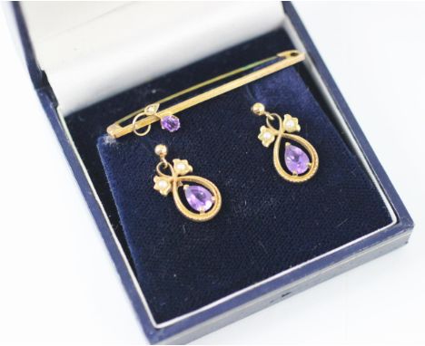 A pair of yellow metal amethyst and seed pearl set drop earrings, the pear shaped amethyst within seed pearl surround designe