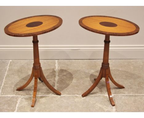 A pair of Regency style satinwood and rosewood cross banded lamp/wine tables, late 20th century, each with an oval top upon a